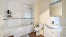 Bathroom with bath, shower screen, sink and toilet.