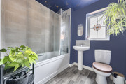 Bathroom with bath, shower screen, wash basin, toilet and window.