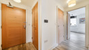 Hallway with wooden entrance door and view towards living area.