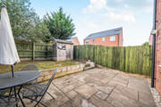 Rear garden with paved patio, outdoor seating, lawn and garden shed.
