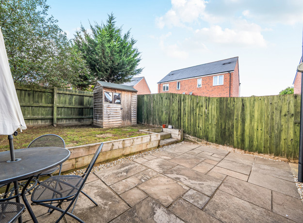 Rear garden with paved patio, outdoor seating, lawn and garden shed.