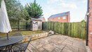 Rear garden with paved patio, outdoor seating, lawn and garden shed.