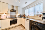 Modern fitted kitchen with integrated oven, hob, sink and worktops.
