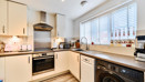Modern fitted kitchen with integrated oven, hob, sink and worktops.