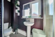 Bathroom with sink, toilet, shower enclosure and window.