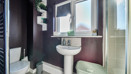 Bathroom with sink, toilet, shower enclosure and window.
