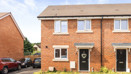 Red brick semi-detached house exterior with front door, windows, and small front garden.