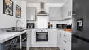 White fitted kitchen with appliances, integrated oven and hob, and worktops.
