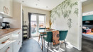 Kitchen and dining area with table, chairs, wall mural and patio doors.