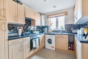 Kitchen with fitted units, worktops, washing machine and window.