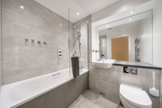 Bathroom with bath, shower, sink, toilet and wall mirror.