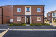Detached brick house with front entrance and surrounding pavement.