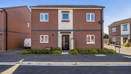 Detached brick house with front entrance and surrounding pavement.