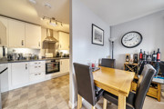 Open-plan kitchen and dining area with table and chairs.