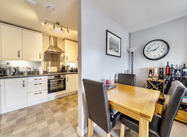 Open-plan kitchen and dining area with table and chairs.