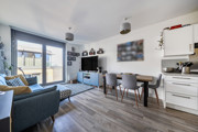 Open-plan living and dining area with seating and balcony access.
