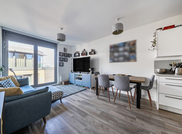 Open-plan living and dining area with seating and balcony access.