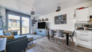 Open-plan living and dining area with seating and balcony access.