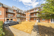 Apartment building courtyard with parked cars and landscaped area.