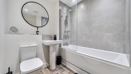 Bathroom with bathtub, shower screen, toilet and wash basin.