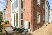 Exterior corner view of a brick apartment building with pathways.