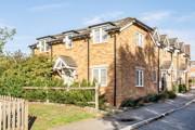 Brick end-of-terrace house with parking area and landscaped frontage.