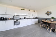 Open-plan kitchen with fitted units, dining table and seating area.