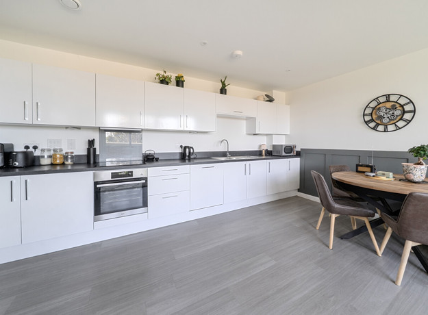 Open-plan kitchen with fitted units, dining table and seating area.