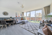 Open-plan living area with dining space and balcony doors.
