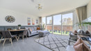 Open-plan living area with dining space and balcony doors.