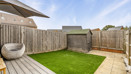 Enclosed rear garden with lawn, decking and storage shed.