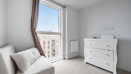 Balcony view from living area with armchair, chest of drawers and radiator.