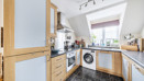 Kitchen with fitted units, appliances and washing machine.