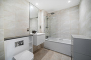 Bathroom with a bathtub, shower screen, vanity unit and toilet.