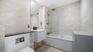 Bathroom with a bathtub, shower screen, vanity unit and toilet.