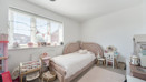 Child's bedroom with a bed, window, rug and toys.