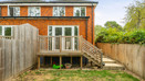 Rear view of the house with a raised wooden deck and steps to the garden.