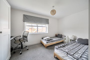 Bedroom with two single beds, study desk, office chair and window.