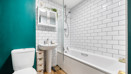 Bathroom with bath, shower, toilet, wash basin and tiled walls.