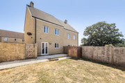 Rear garden with lawn and fenced boundaries behind the house.