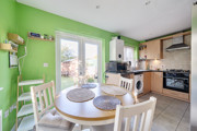 Kitchen and diner with round table, chairs and patio doors to the garden.