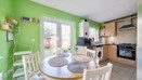 Kitchen and diner with round table, chairs and patio doors to the garden.