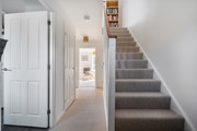 Hallway with staircase, internal doors and view towards the rear of the house.