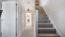 Hallway with staircase, internal doors and view towards the rear of the house.