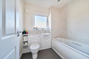 Bathroom with toilet, sink, bathtub and frosted window.