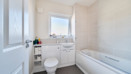 Bathroom with toilet, sink, bathtub and frosted window.