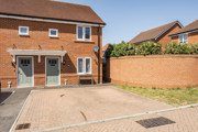 Semi detached brick house with white windows, green front door and driveway