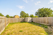 Enclosed rear garden with lawn, wooden fencing and a garden shed.