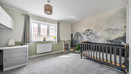 Bedroom with cot, chest of drawers, window and feature wall.