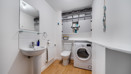 Utility room with sink, washing machine, storage shelves and worktop.